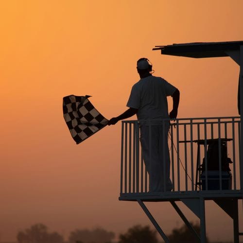 man in white shirt holding us a flag