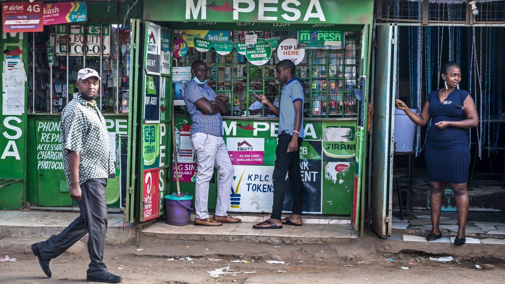 Residents use M-pesa services at a local kiosk in Kibera slum, Nairobi, Kenya.